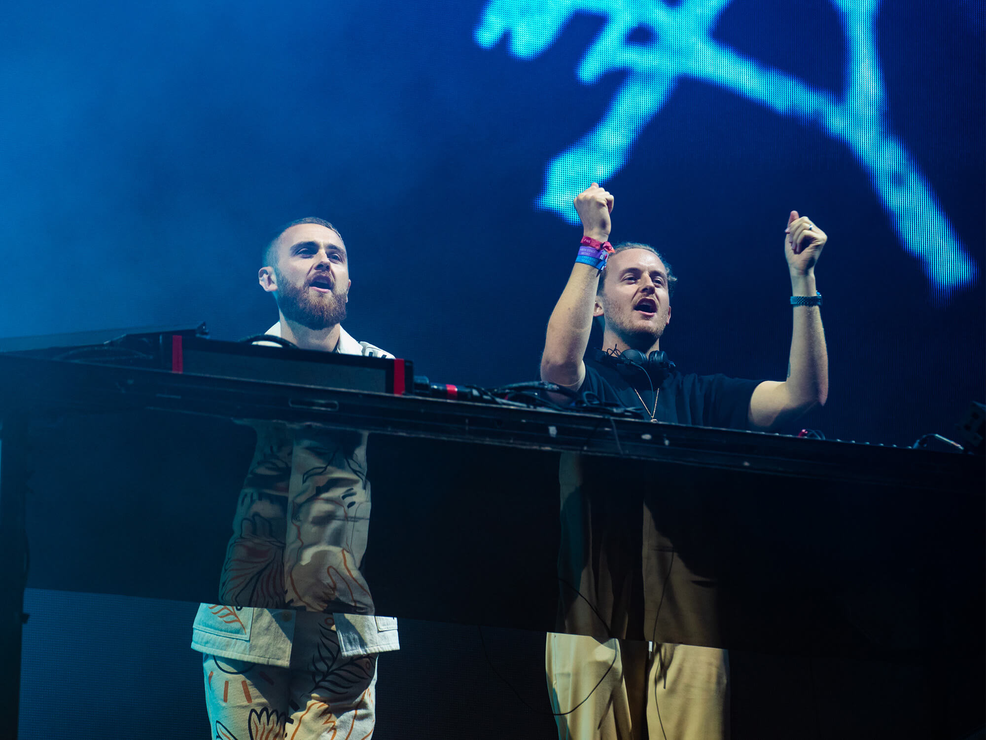 Disclosure standing behind the decks and cheering at the crowd.